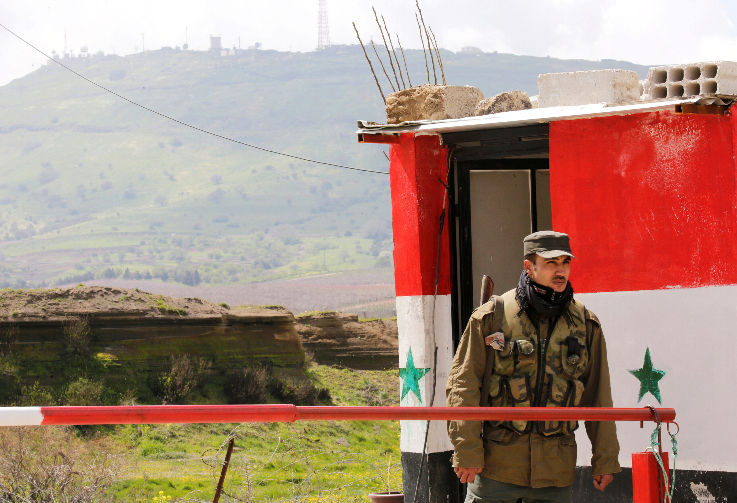 FILE PHOTO: A Syrian army soldier stands at a checkpoint at the Quneitra crossing between the Israeli-controlled Golan Heights and Syria, seen from the Syrian side in Quneitra, Syria March 26, 2019. REUTERS/Omar Sanadiki/File Photo